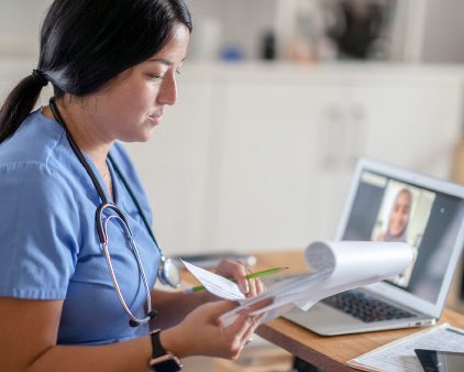 Nurse looking over files at computer