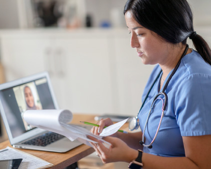 Nurse looking over files at computer