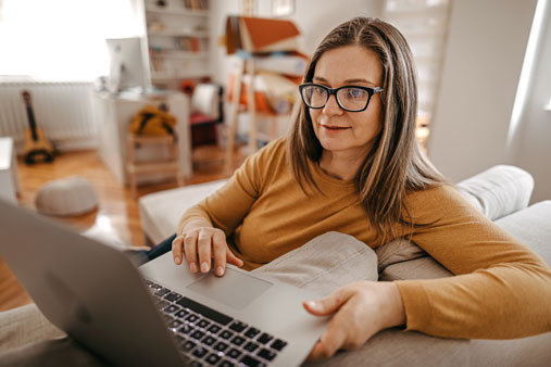 Woman receiving virtual mental health care on laptop