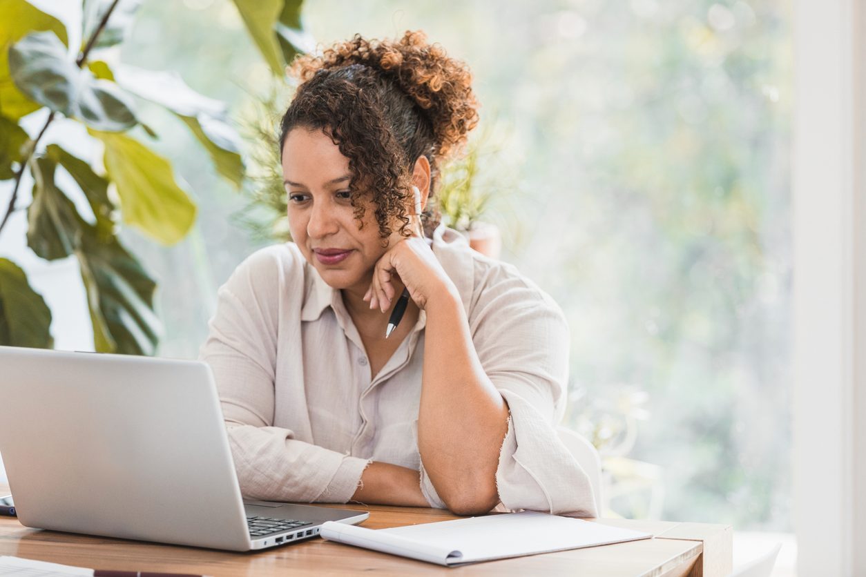 Woman sitting infront of a laptop computer at home