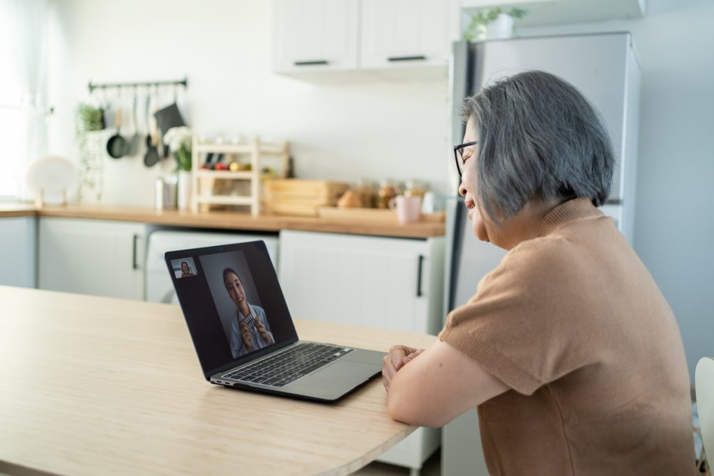 senior woman in a video call with doctor in living room at home