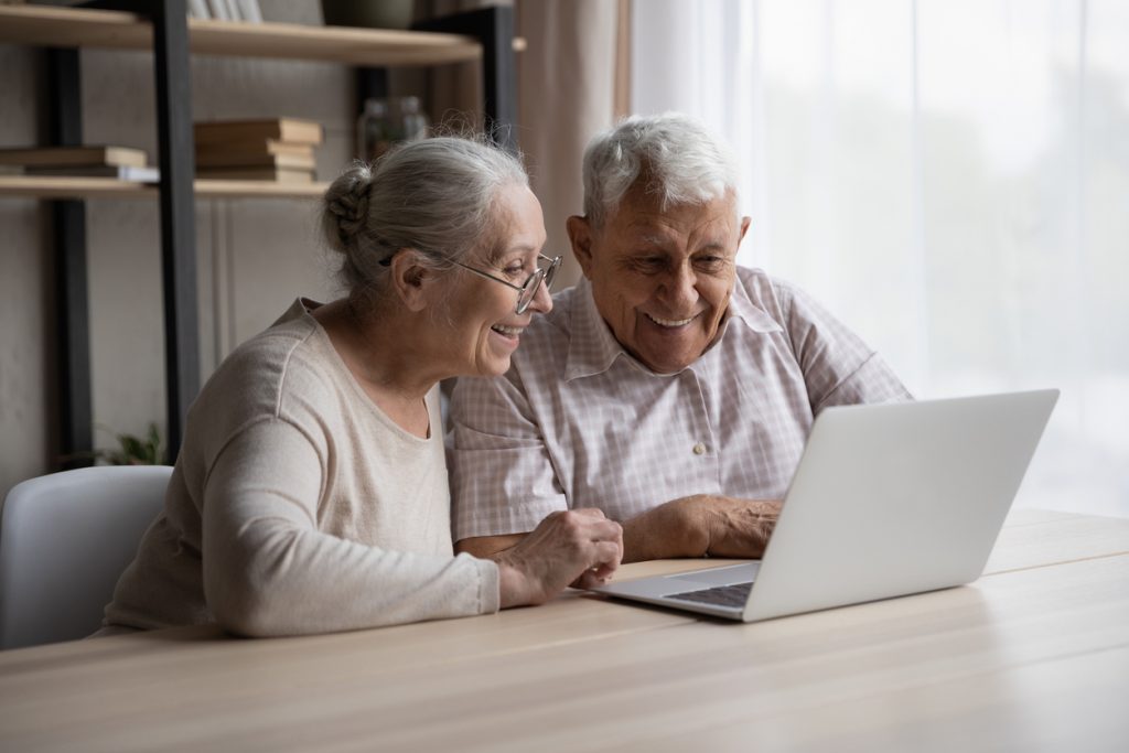 Happy older couple using laptop